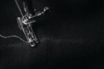Closeup black and white photograph of a sewing machine presser foot